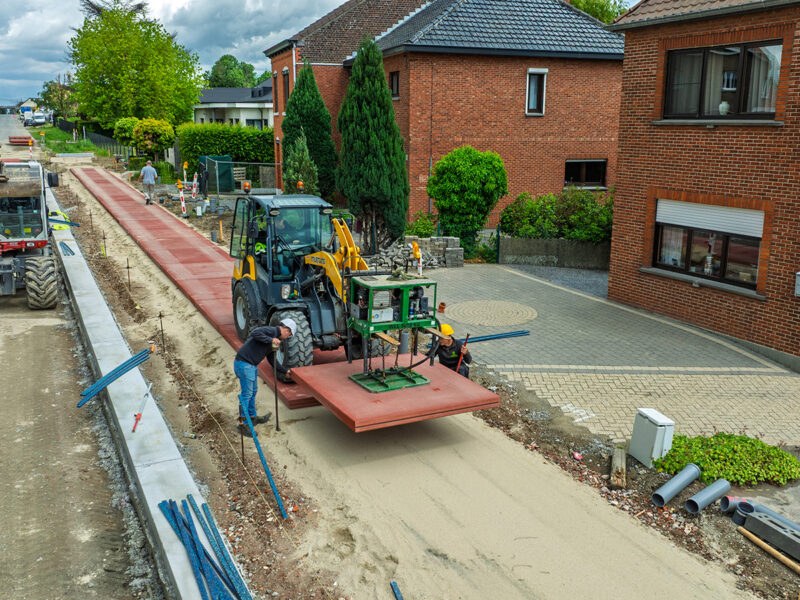 Plaatsing van rode prefab Ecopath-elementen langs de Hasseltsesteenweg in Sint-Truiden