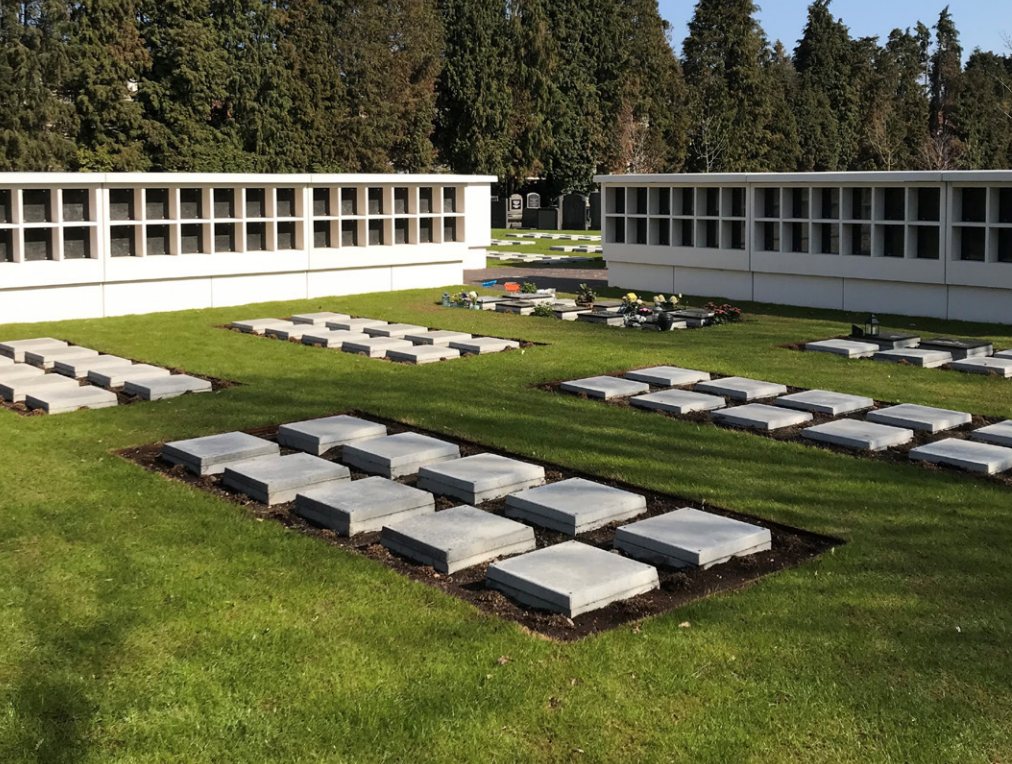 Begraafplaats met columbaria, graszones en betonnen grafplaten